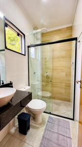 a bathroom with a toilet and a glass shower at Apto central ideal para casais e famílias em Foz 3 in Foz do Iguaçu +25 photos
