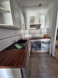 uma pequena cozinha com armários brancos e um lavatório em LE MARIUS 2 PIECES 4 personnes Coeur de ville em Mèze