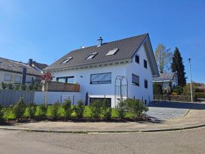a white house with a gray roof on a street at Stegmann Horn in Gaienhofen