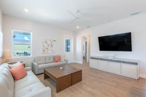 een woonkamer met een bank en een flatscreen-tv bij Tranquil Daze by Sun Palace Vacations in Fort Myers Beach
