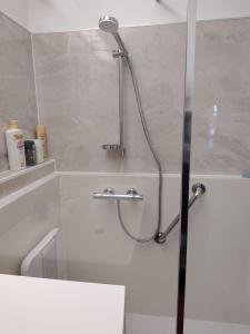 a shower with a glass door in a bathroom at "Les Antilles " Héhergement chez l'habitant in Marseille