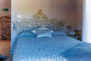 a blue bed with an ornate headboard in a bedroom at El Apartamentín de Verdiago in Verdiago +38 photos
