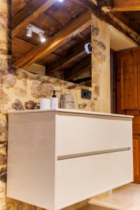a white counter in a kitchen with a stone wall at La Casita de Verdiago in Verdiago