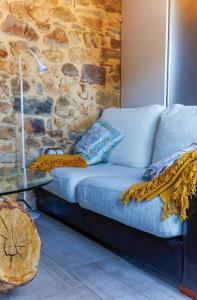 a blue couch in a room with a stone wall at El Apartamentín de Verdiago in Verdiago