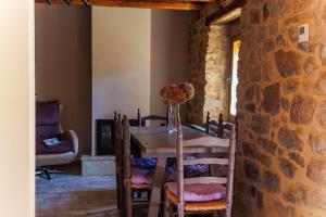 a dining room with a table and a stone wall at La Casita de Verdiago in Verdiago