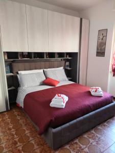 una camera da letto con un letto grande con asciugamani sopra di AndEli ad Alghero