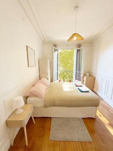 a bedroom with a large bed and a window at Parisian Apartment for 3 People - Paris Parc des Princes WiFi & Metro in Boulogne-Billancourt