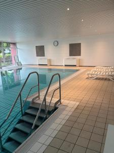a swimming pool with stairs in a building at Ferienwohnung Studio 205 im Taunusblick in Lahnstein