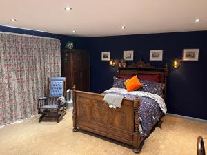 a bedroom with a bed and a chair at Williams Cottage A High end little home with antique style in Tarporley