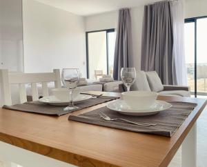 a dining room table with two plates and wine glasses at Medsal Residence in Prainha +1 photo