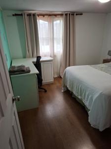 a bedroom with a bed and a desk and a window at Cabañas en Constitución Bosque Mar in Constitución