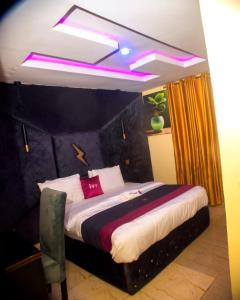 ein Schlafzimmer mit einem großen Bett mit rosa Beleuchtung in der Unterkunft Ivy Hotel Epe in Poka + 42 Fotos