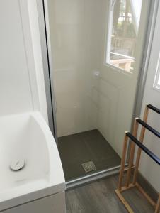 a bathroom with a shower with a glass door at Mobil home 6 personnes in La Celle-sous-Gouzon