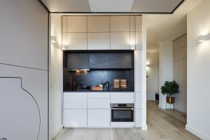 a kitchen with white cabinets and a stove at The Hill by Nestor in Harrow +37 photos