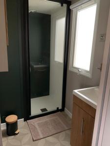a bathroom with a mirror and a sink at Mobil home 4 personnes in Pont-Aven