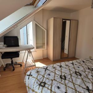 ランブイエにあるMaison familiale - Promo Toussaint - Paris 35 minのベッドと机と窓のある寝室