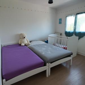 ランブイエにあるMaison familiale - Promo Toussaint - Paris 35 minの寝室のベッドの上に座っているテディベア