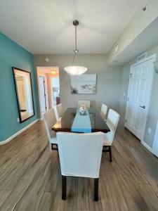 una sala da pranzo con un tavolo e sedie bianche di An Emerald Coast Escape a Destin