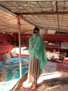 a woman is standing under a tent at Al Salam Camp Bidiyah in Badīyah