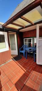 eine Terrasse mit einem blauen Tisch und einer Bank in der Unterkunft Ferhaus Albertsdorf am Dorfteich  Wohnung 4 in Teschendorf