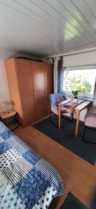 ein Zimmer mit einem Bett und einem Tisch und einem Fenster in der Unterkunft Ferhaus Albertsdorf am Dorfteich  Wohnung 4 in Teschendorf + 2 Fotos