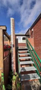 eine Treppe, die zu einem Backsteingebäude führt in der Unterkunft Ferhaus Albertsdorf am Dorfteich  Wohnung 4 in Teschendorf