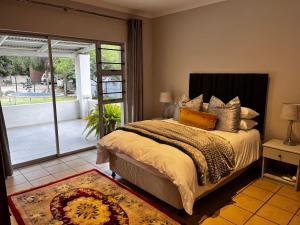 a bedroom with a bed and a large window at Dorpshuisie in Uniondale