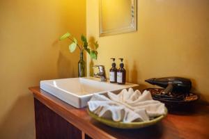 a bathroom sink with towels on a wooden counter at Lake Chahafi Resort in Kisoro