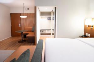 a bedroom with a white bed and a table at Estanplaza Berrini in Sao Paulo