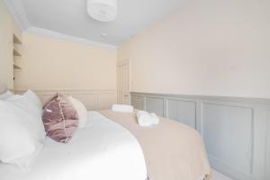 a bedroom with a white bed with white pillows at Romantic Getaway Apartment in Central Bath in Bath