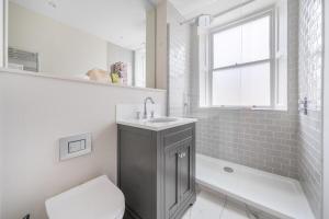 a bathroom with a sink and a toilet and a tub at Romantic Getaway Apartment in Central Bath in Bath