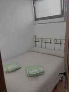 ein Schlafzimmer mit einem Bett, auf dem zwei grüne Behälter stehen in der Unterkunft Casa museo junto al río in Cortes de la Frontera