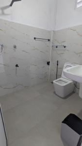 Un baño blanco con inodoro y lavabo. en Sea View Villa, Galle, en Galle