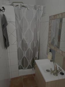 ein Badezimmer mit Duschvorhang und Waschbecken in der Unterkunft Casa museo junto al río in Cortes de la Frontera