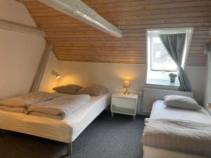 a bedroom with two beds and a window at Landligt ophold på Midtgård in Vamdrup