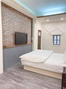 a bedroom with two beds and a flat screen tv at 九份巷居民宿 in Jiufen