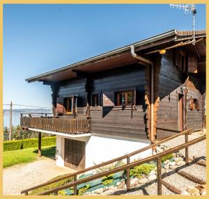 a log house with a porch and a balcony at Le Chalet de Jacky I Vue Lac I Lugrin in Lugrin