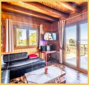 a living room with a leather couch and a table at Le Chalet de Jacky I Vue Lac I Lugrin in Lugrin