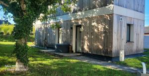 a wooden building with a door and a tree at Le Cercle de Victoria in Bourges