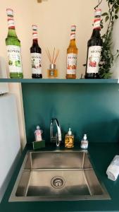 a kitchen sink with bottles on shelves above it at Le Cercle de Victoria in Bourges +21 photos