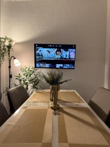 a dining room table with a television on the wall at Le Nomad Homestay in Batangas City