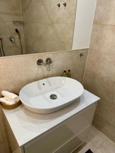 Cozy and modern apartment في فيتسلار: حمام مع حوض غسيل أبيض ودش