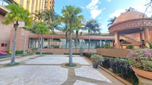 a courtyard with palm trees in front of a building at Signature Apartment Berjaya Times square Bukit Bintang in Kuala Lumpur
