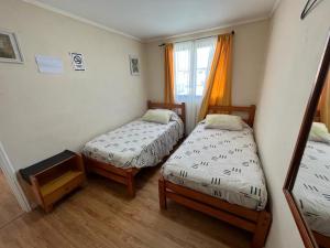 a room with two beds and a window at Hostal Rosario in La Serena