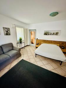 a bedroom with a large bed and a couch at Mamisà 3, appartamento con giardino privato in Schio