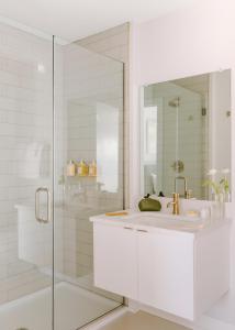 Un baño blanco con lavabo y ducha. en Sosuite at The Ovation - Ave of The Arts, en Filadelfia