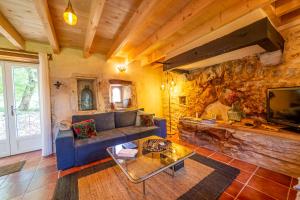 a living room with a blue couch and a stone wall at La Pause noble val in Saint-Antonin