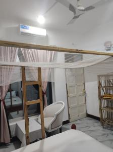 a room with a bunk bed and a chair at Nils Home in Nungwi