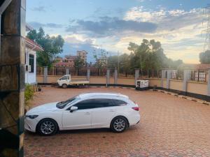 a white car parked in a brick parking lot at Doreen Executive Inn in Morogoro