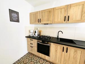 a kitchen with wooden cabinets and a black counter top at Halte romantique in Ault +14 photos